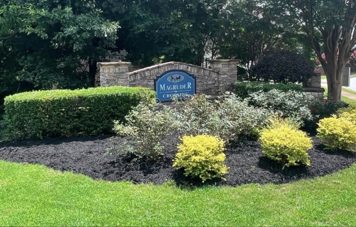 Finished black mulch beds at a subdivision entrance