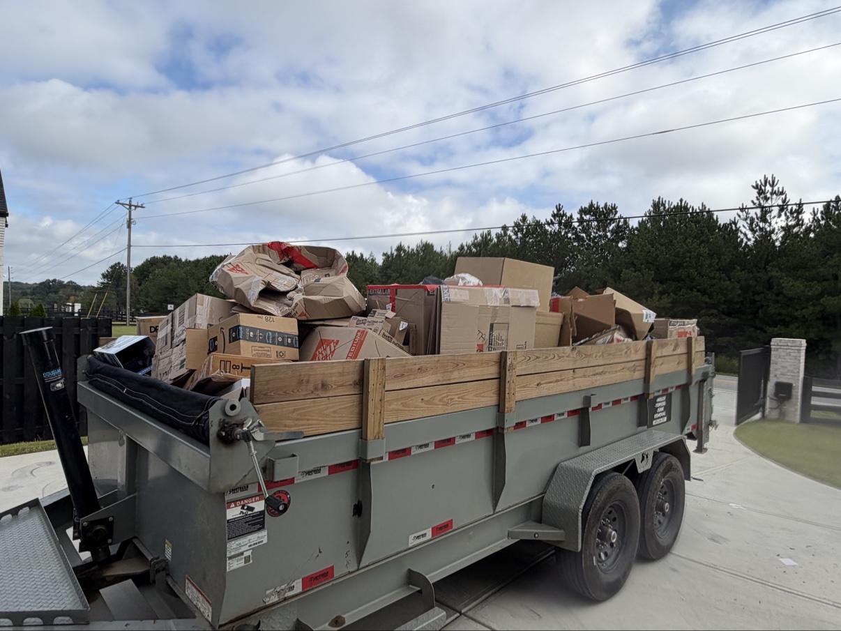 Dump trailer loaded with cardboard boxes hauled away from the garage